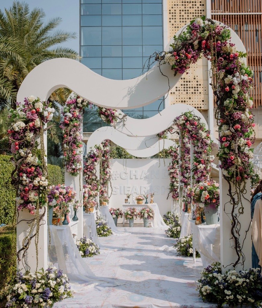 Luxurious outdoor destination wedding with grand floral arch installation